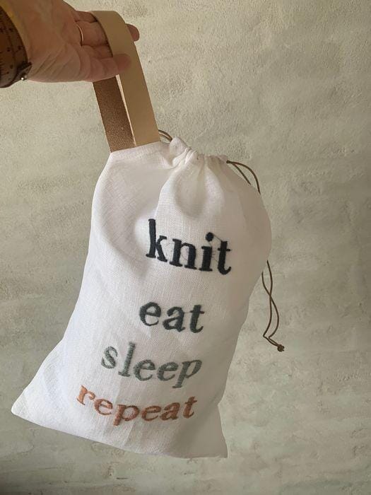 Project bag with embroidered text knit, eat, sleep, repeat, hanging