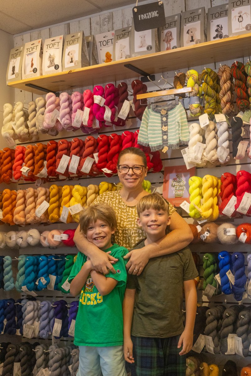 Joey and her kids at the homesewn yarn wall — featured in the Swarthmorean