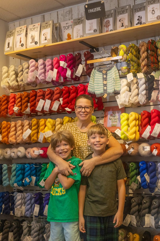 Joey and her kids at the homesewn yarn wall — featured in the Swarthmorean