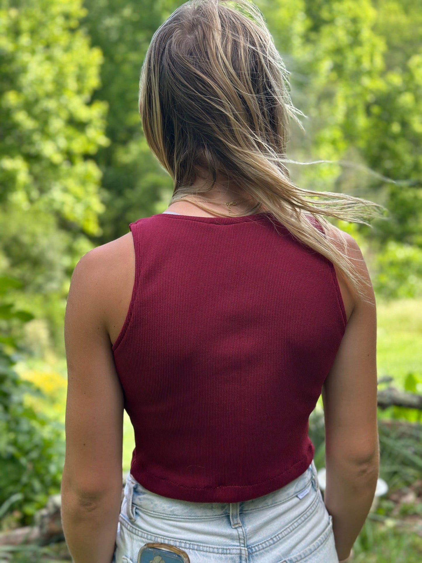 woman standing outside wearing a red tankini with her back to the camera