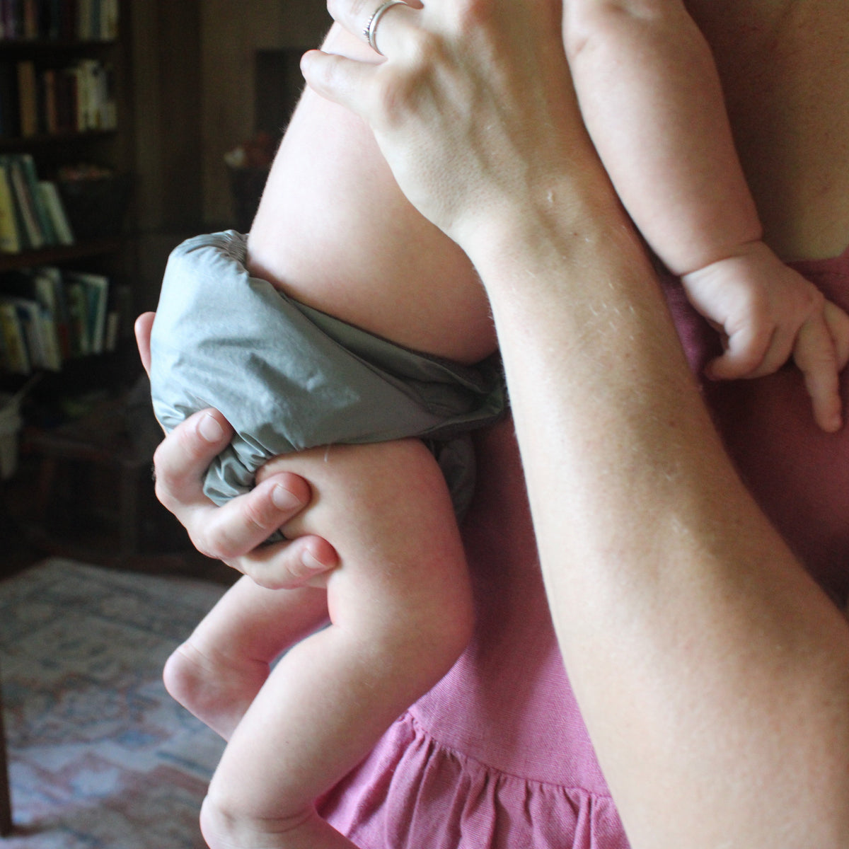 close up of baby in a cloth diaper in moms arms