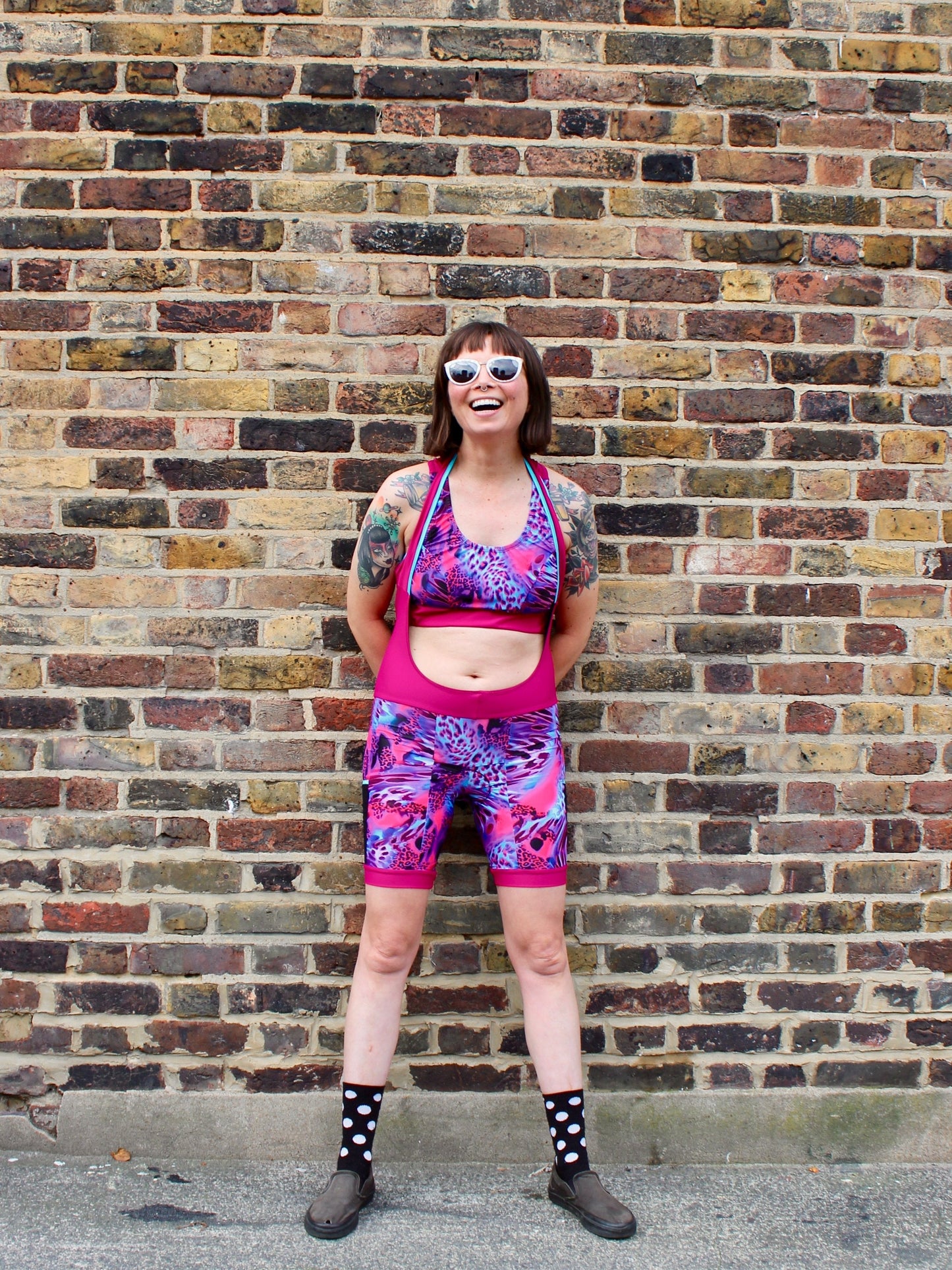 Rouleur Leggings view B - image of woman in brightly coloured bib shorts standing against a brick wall