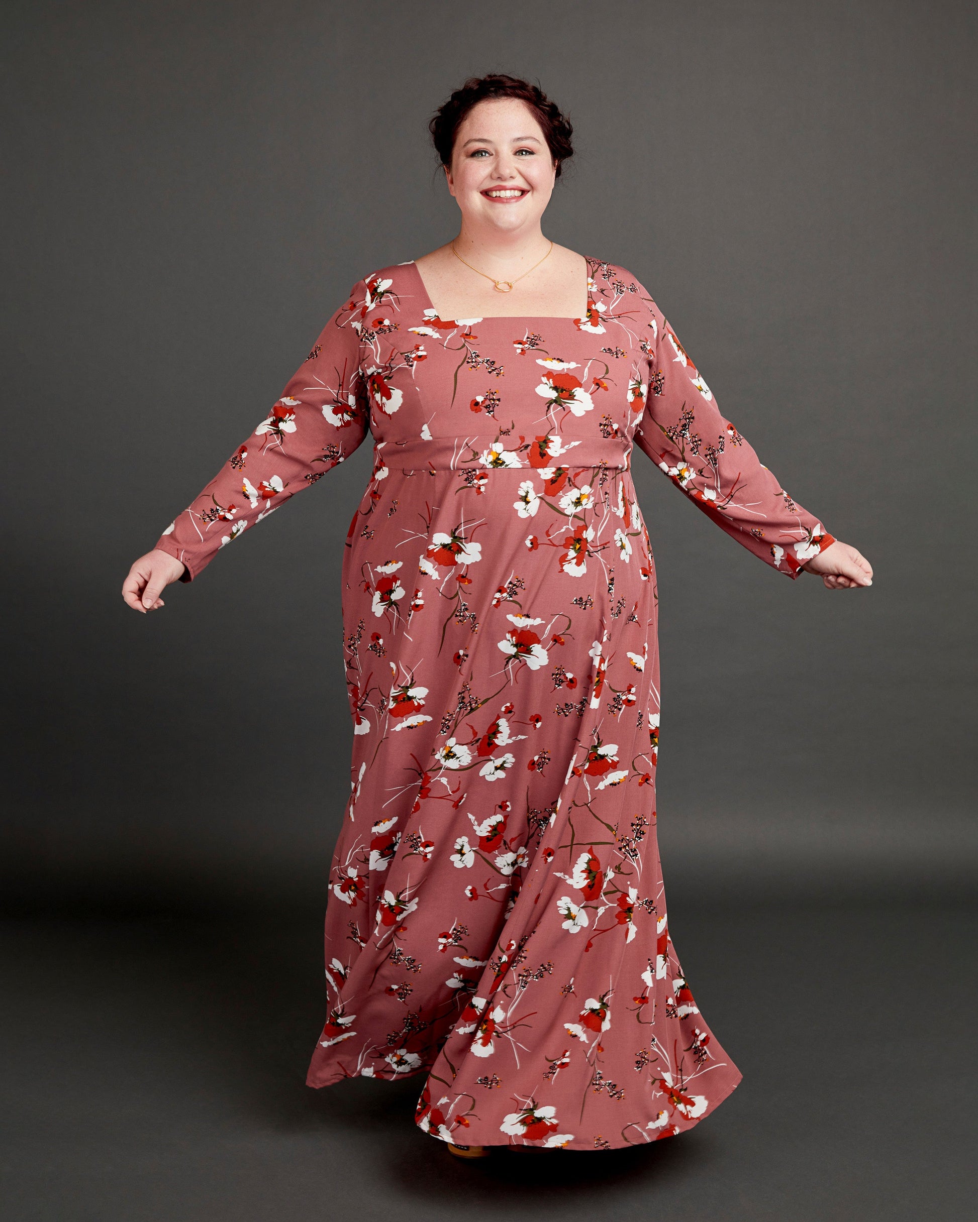 Woman wearing a long floral dress against a gray background. This dress is the Upton Dress & Skirt sewing pattern from Cashmerette.