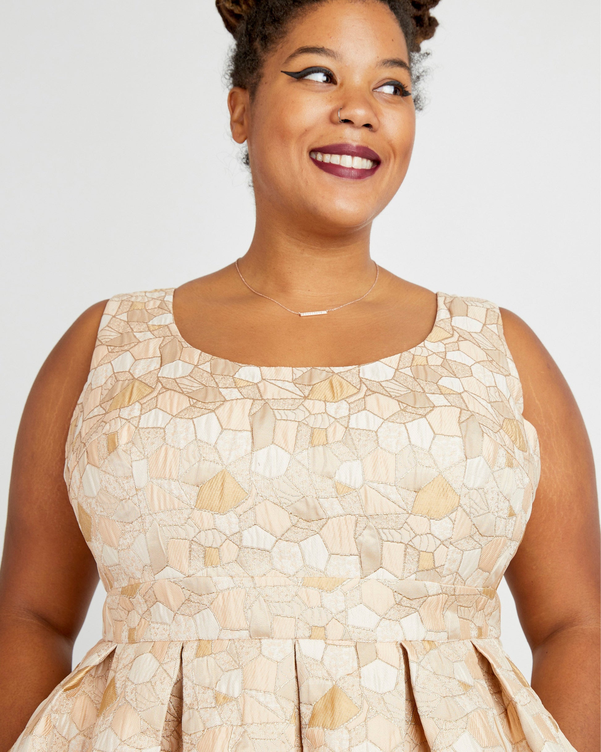 Woman wearing a beige patterned dress against a plain background. This dress is the Upton Dress & Skirt sewing pattern from Cashmerette.