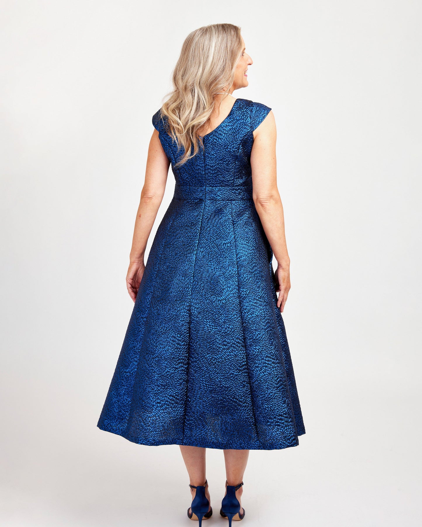 Woman wearing a blue lace dress on a white background. This dress is the Upton Dress & Skirt sewing pattern from Cashmerette.