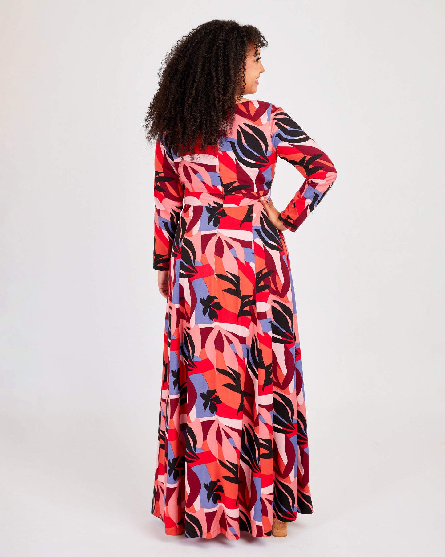 Woman wearing a colorful patterned dress on a white background. This dress is the Upton Dress & Skirt sewing pattern from Cashmerette.
